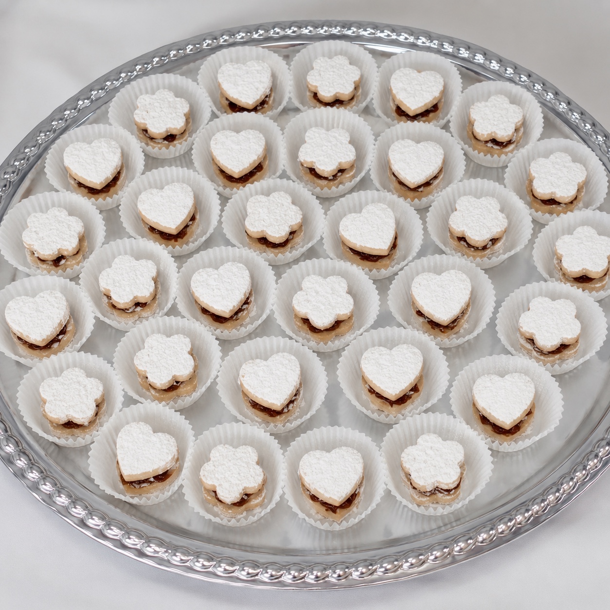 Bandeja plateada con 30 alfajores bites en forma de corazón y flor